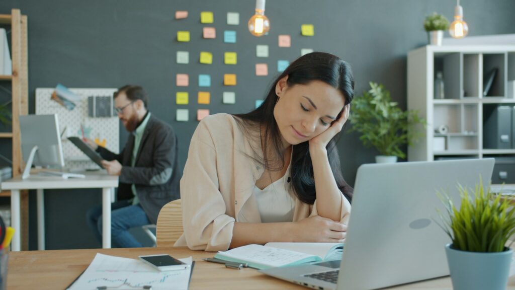 Woman leaning on a desk reflecting on her mental health